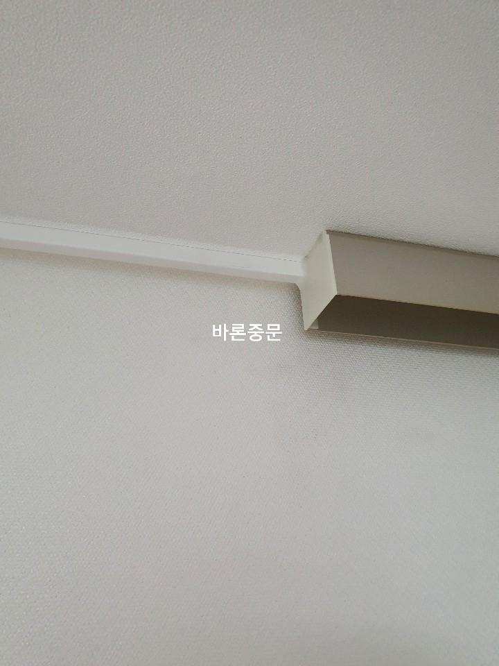 흰색 벽지와 맞닿은 금속 프로파일 마감 상태