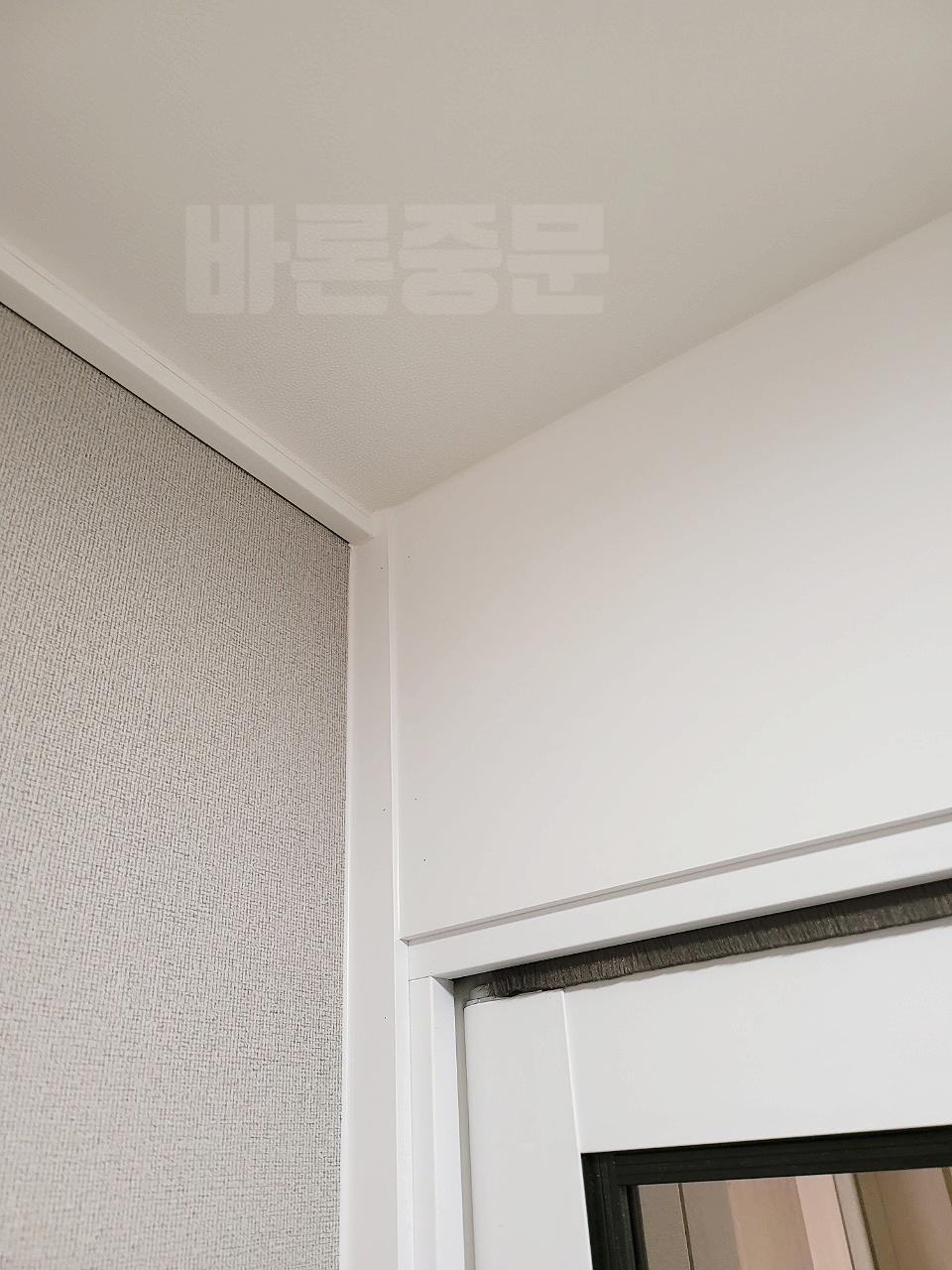 베이지색 도배와 흰색 상판이 이어지는 실내 모서리