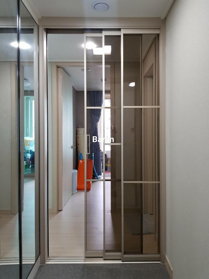 베이지색 마루 위로 설치된 도어 유리 패널