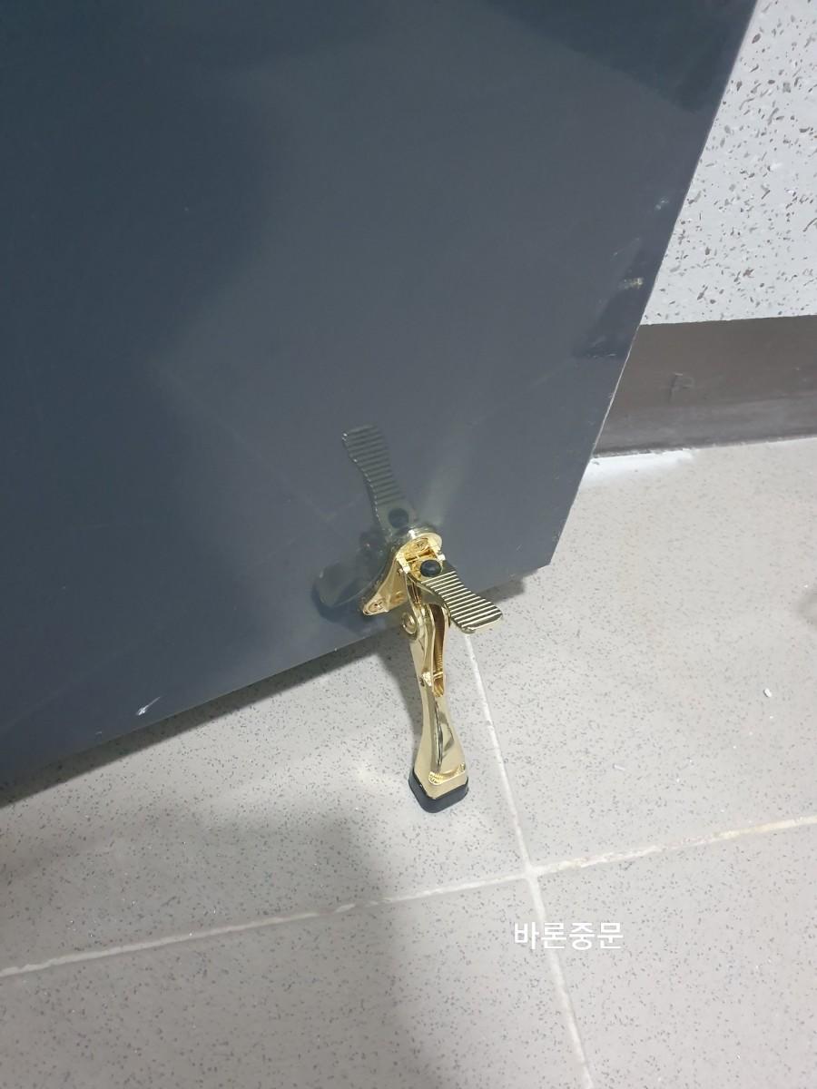 바닥에 고정된 골드 컬러의 금속 부품