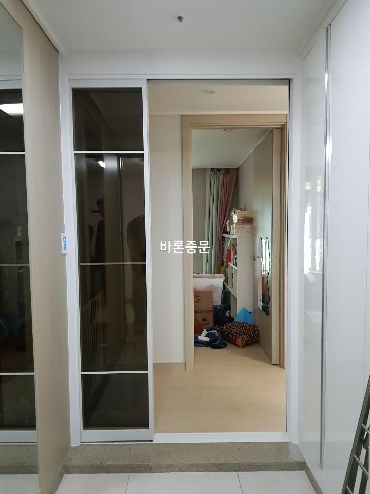 타일과 목재 바닥의 경계에 설치된 슬라이딩 도어