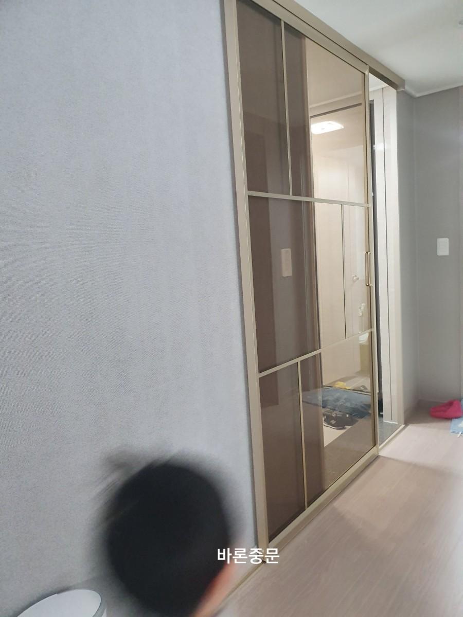 회색 벽지와 목재 마루가 보이는 복도 시공 과정