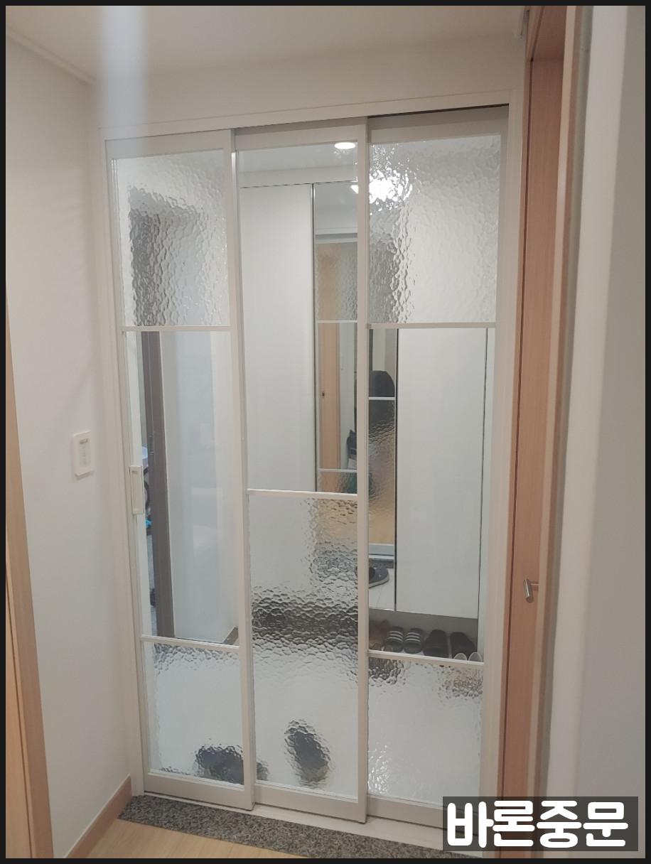 흰색 벽면과 조화를 이루는 슬라이딩 도어