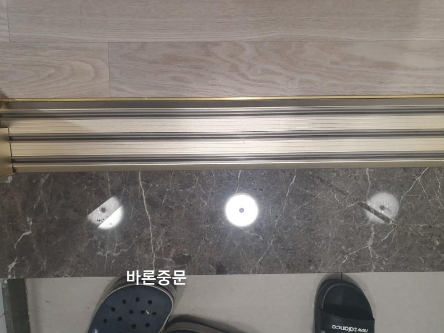 문틀 금속 장식과 바닥 마감재 근접 모습