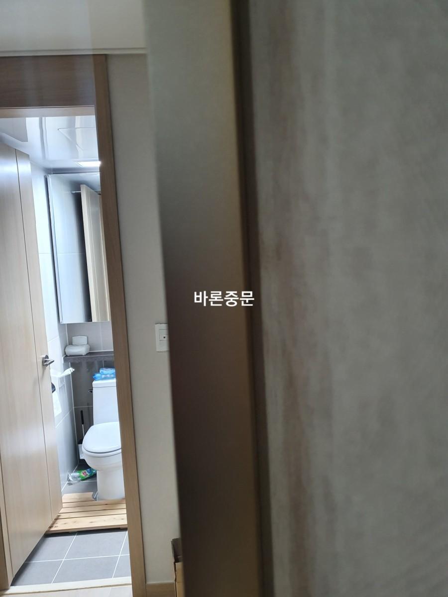 거울과 양변기, 샤워 설비가 보이는 내부 시공 모습