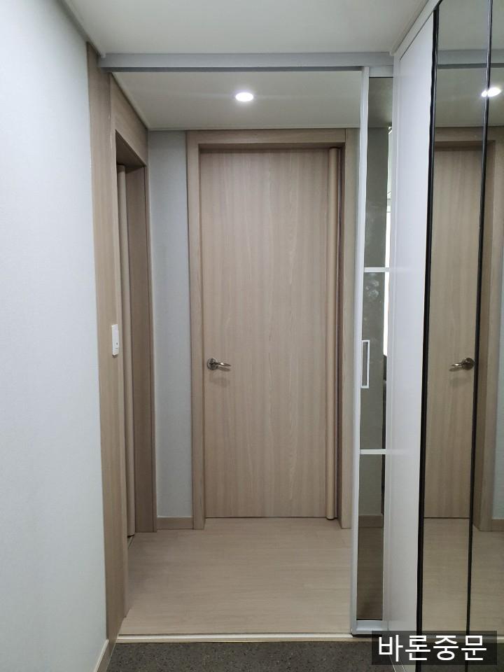 베이지색 마루와 흰색 벽면의 복도 전경