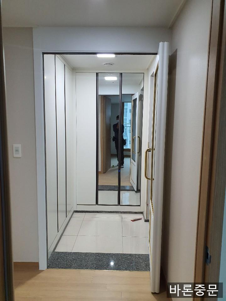 투명 유리와 금색 손잡이로 마감된 화이트 도어