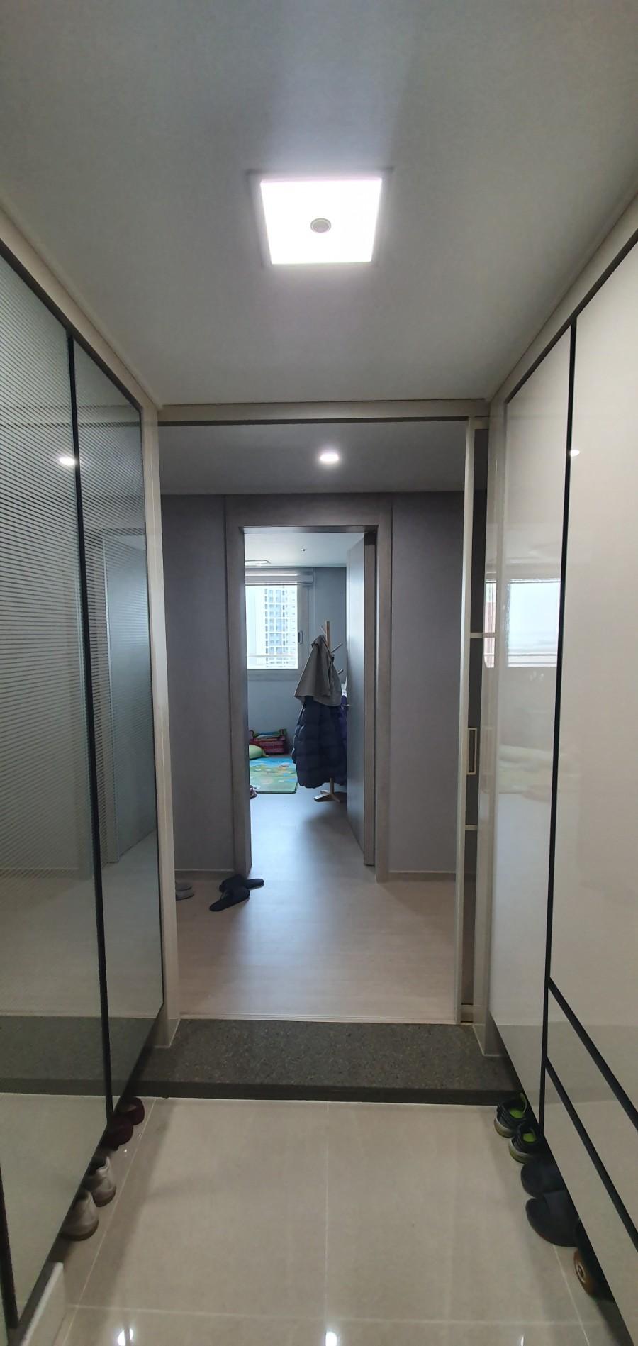 현관 타일 바닥과 중문이 설치된 통로