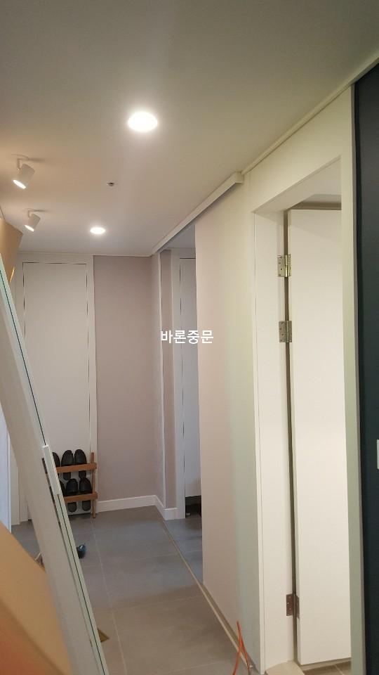 분홍색 도배와 조명이 설치된 복도 전경
