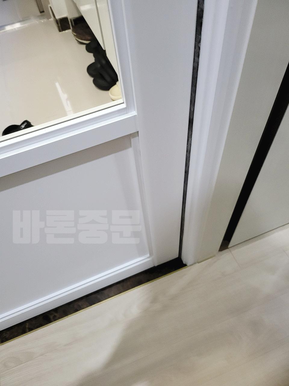 검은색 선 장식이 있는 현관 문 시공 모습