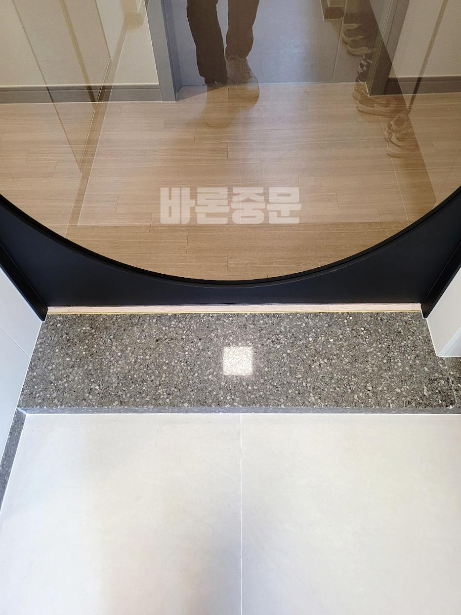 나무 패턴 마루와 회색 타일이 만나는 현관 시공 모습