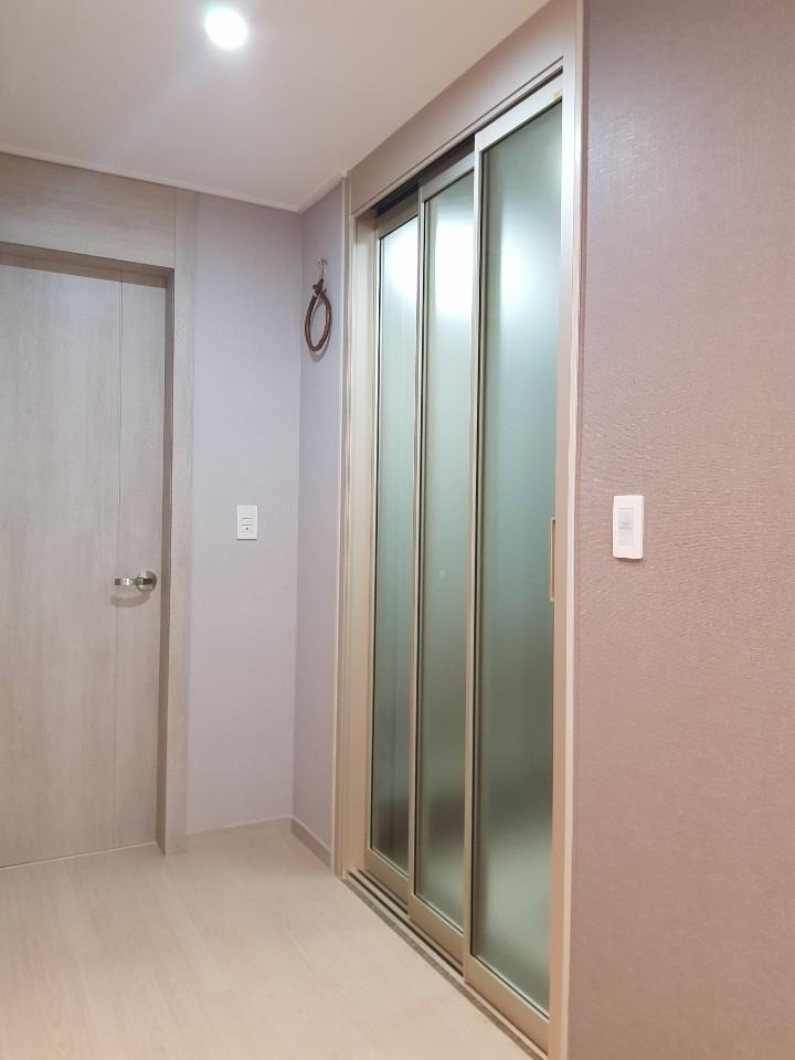 베이지색 벽면과 조화를 이루는 복도 슬라이딩 도어