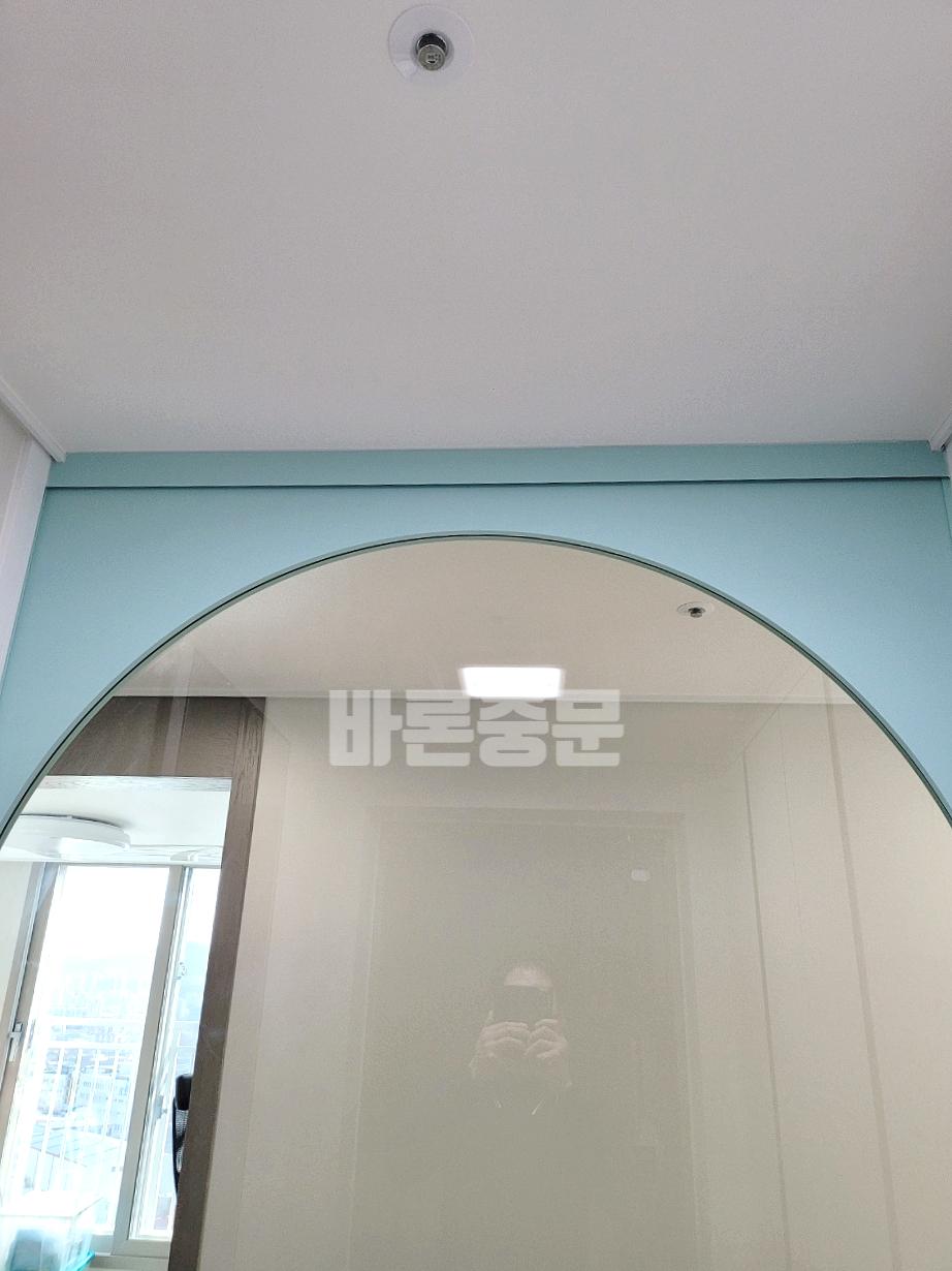 아치형 거울과 연두색 벽면이 어우러진 실내 공간
