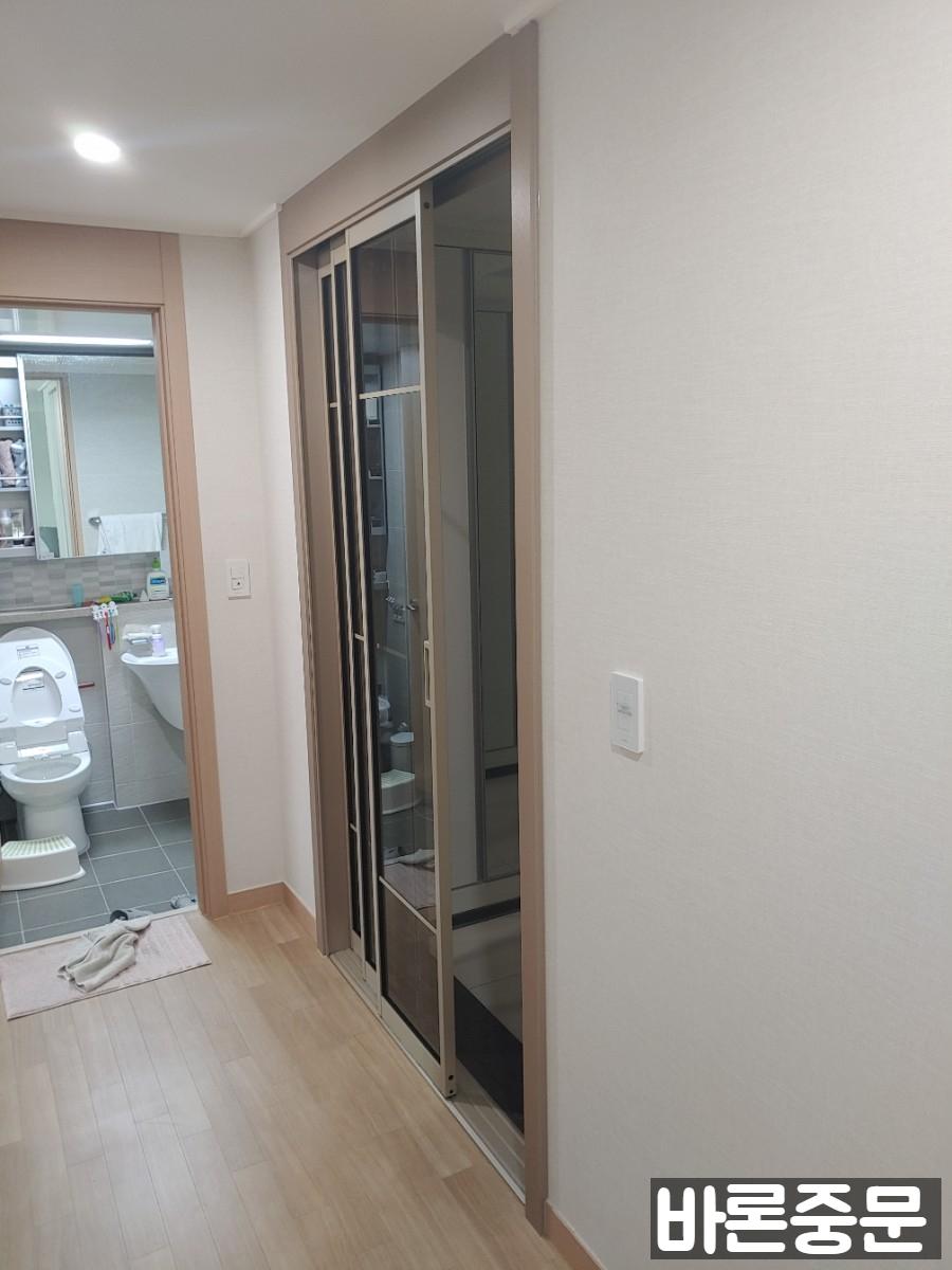 베이지색 벽지와 목재 바닥이 있는 실내 공간