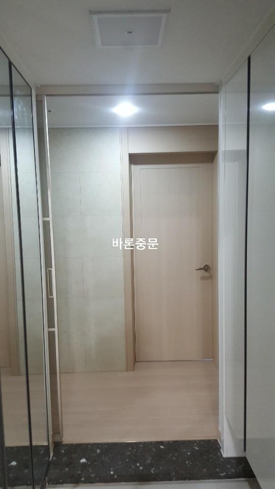 베이지색 도어와 유리문이 설치 중인 현관