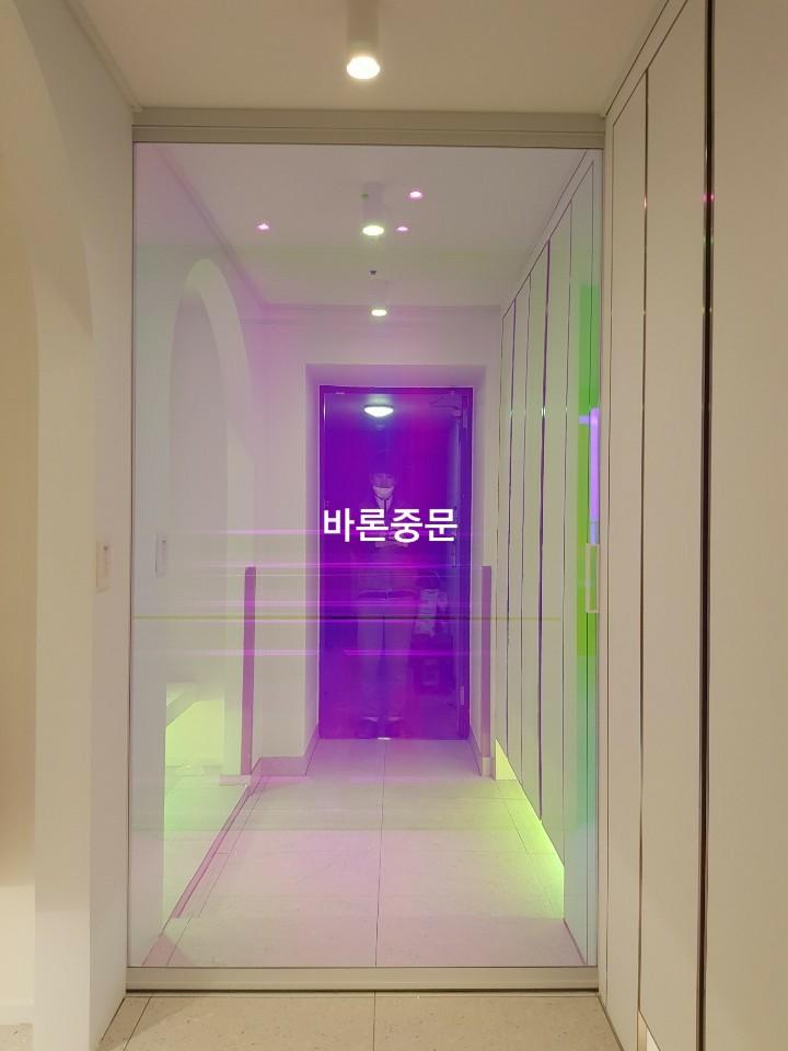 보라색 조명이 투영되는 유리문 설치 마무리 단계