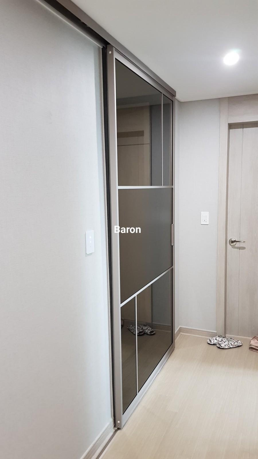 슬라이딩 도어가 설치된 벽면과 바닥재, 벽등이 보이는 모습