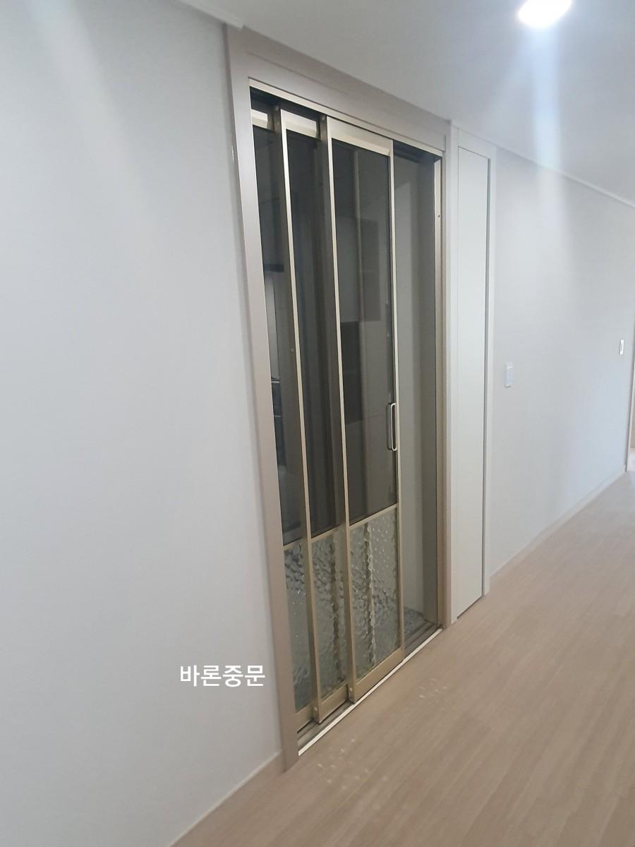 흰 벽과 목재 바닥 사이에 설치된 중문