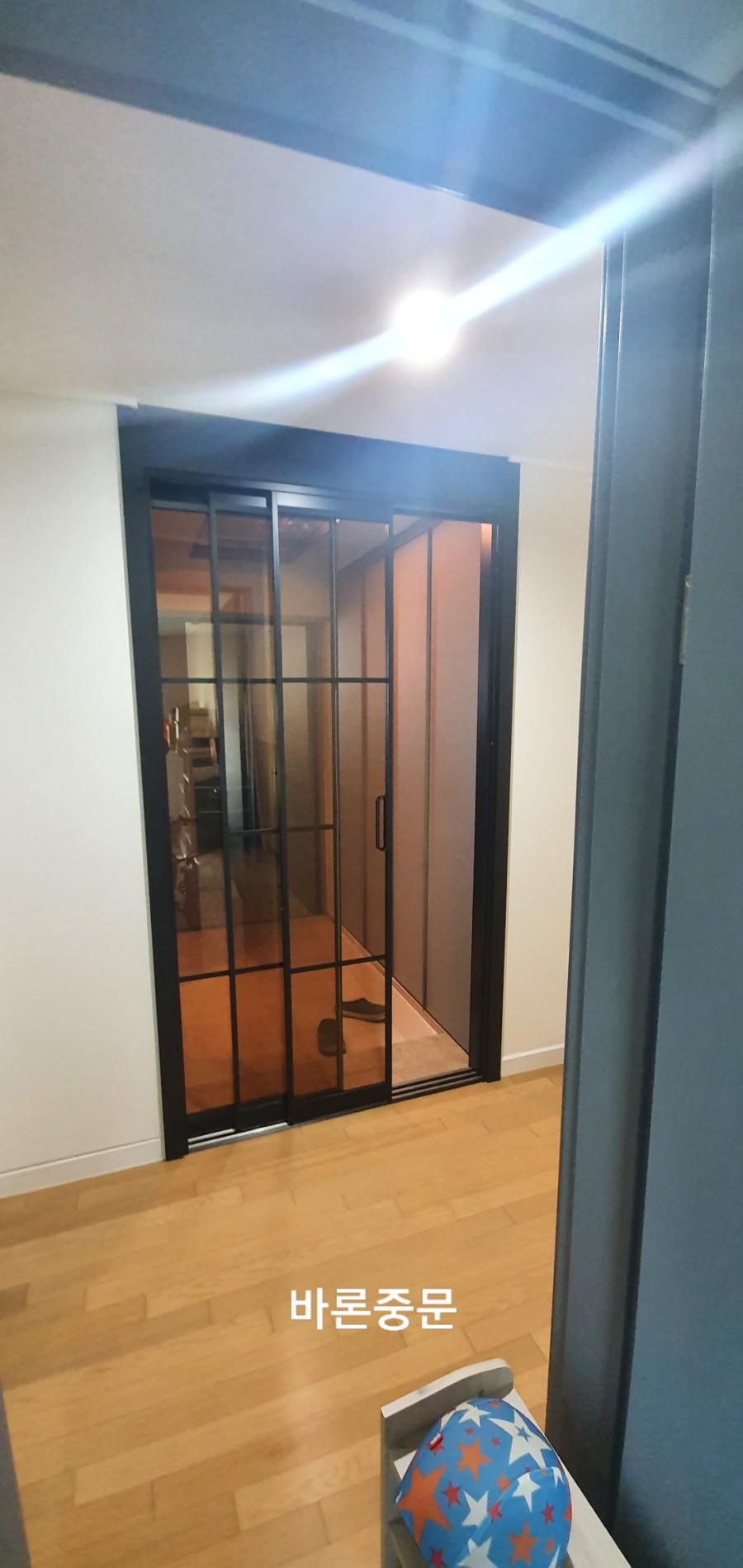 흰 벽과 목재 바닥 사이의 검은 테두리 도어