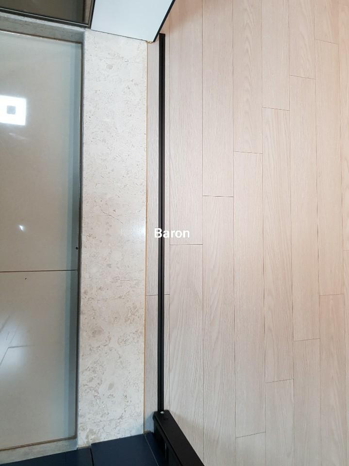 바닥재 접합부와 블랙 도어 핸들의 디테일