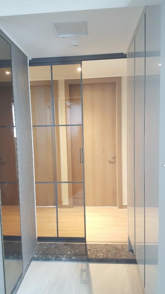 유리와 목재 패널로 구성된 슬라이딩 도어의 설치 과정