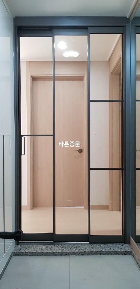 베이지톤 배경과 대비되는 블랙 슬라이딩 도어