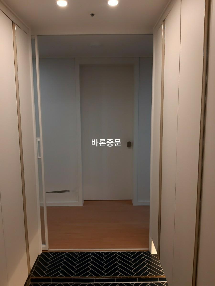 타일 바닥과 나무 마루가 교차하는 복도 진입로