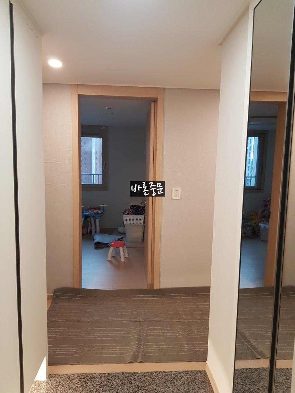 흰색 벽면과 석재 바닥이 이어지는 복도 전경