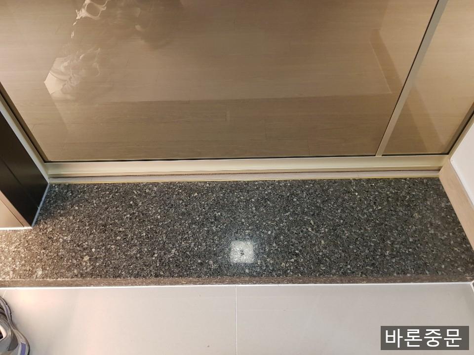 검은색 석재 바닥과 맞닿은 하부 마감 근접 샷