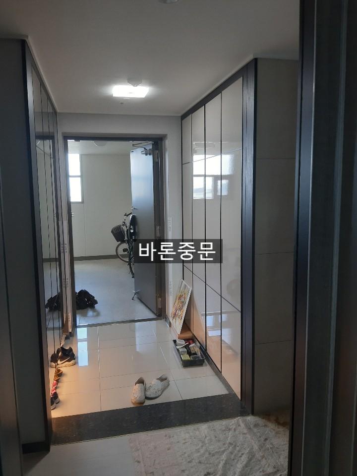 흰색 타일 바닥이 깔린 현관 내부의 시공 전 모습
