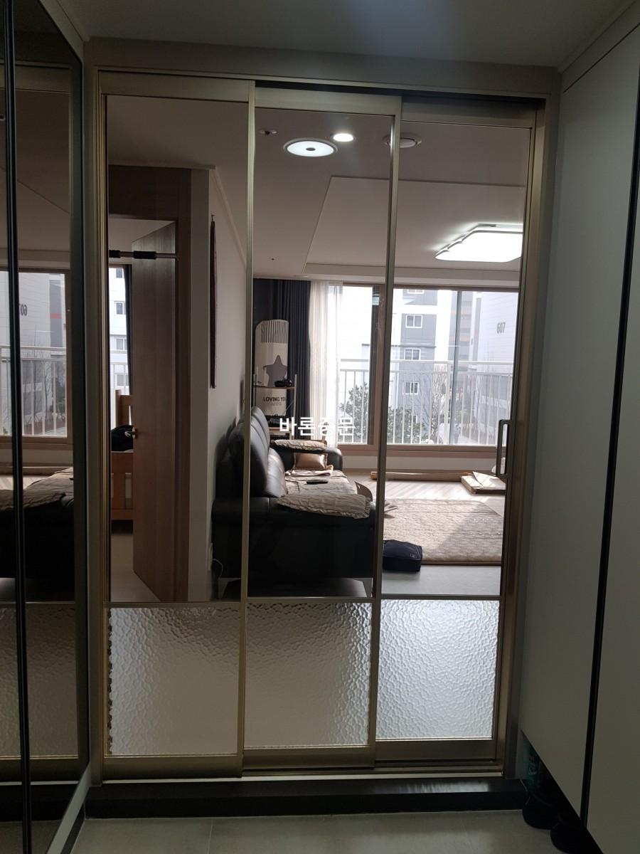 라운드 램프와 카펫이 배치된 거실 배경의 중문 설치 과정