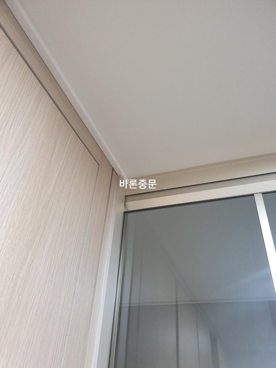 슬라이딩 도어 상단 프레임과 유리 패널의 근접 샷