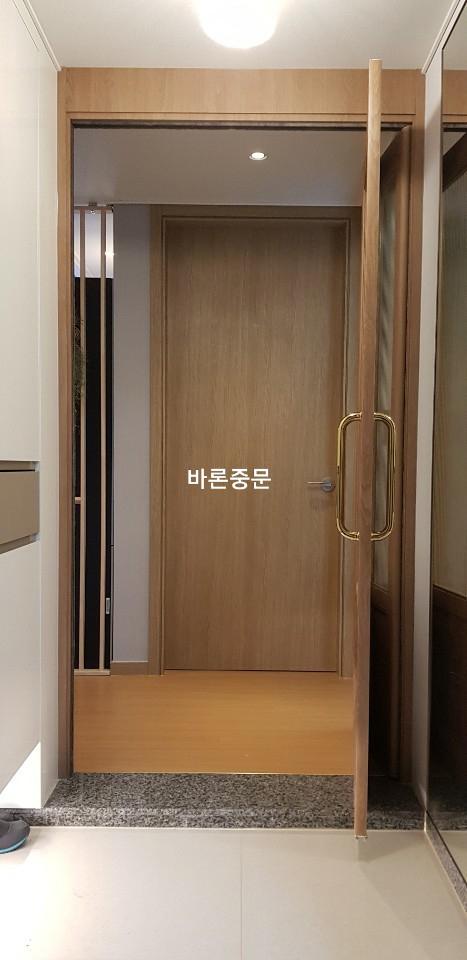목재 프레임과 유리 패널이 결합된 도어 설치 과정