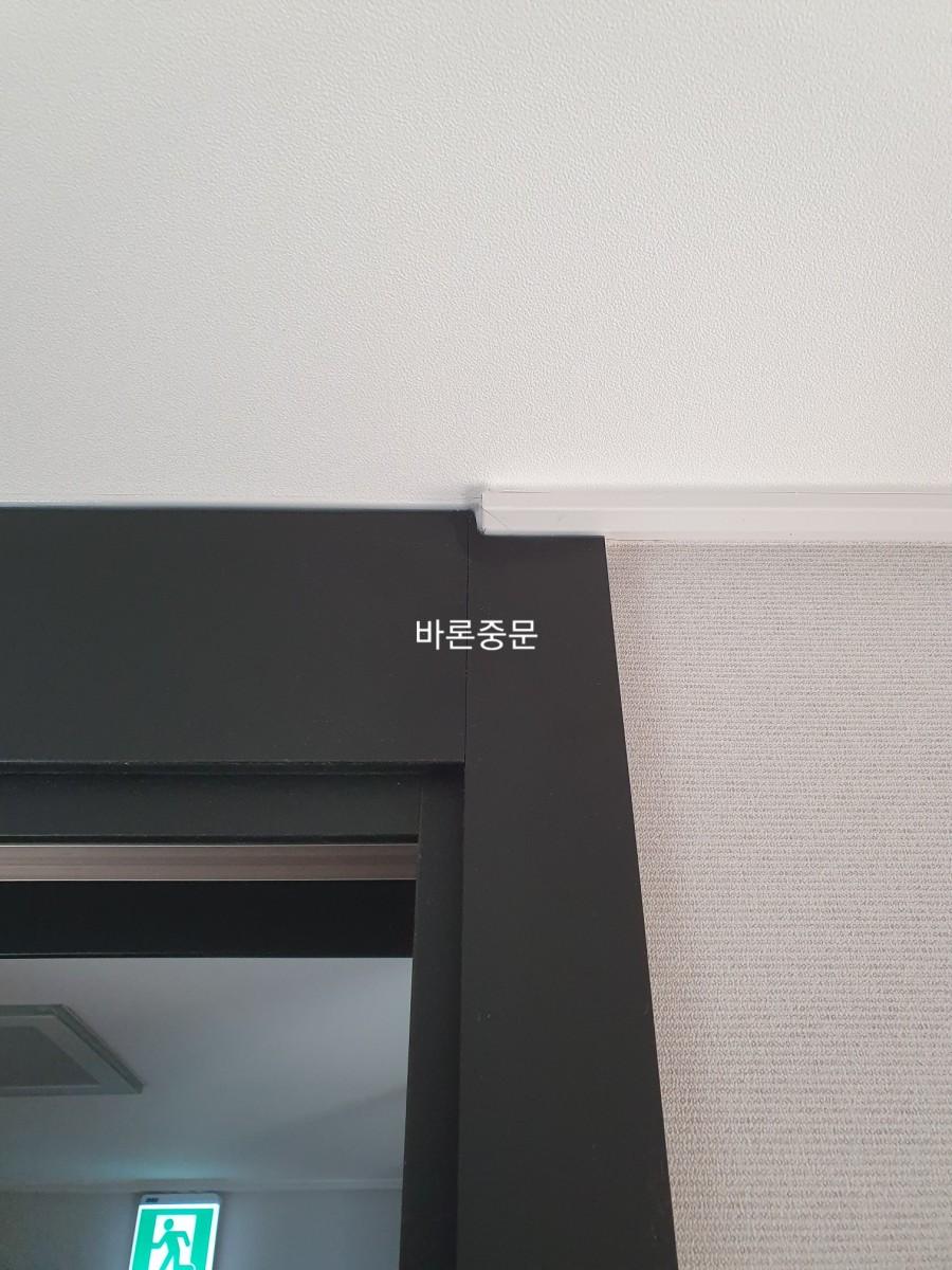 문틀과 벽면 사이의 화이트 몰딩 마감