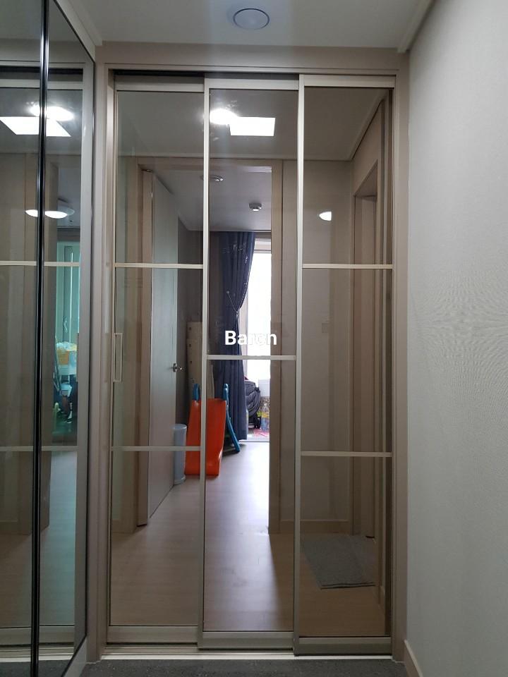 벽지와 마루재 사이에 고정된 슬라이딩 도어 프레임