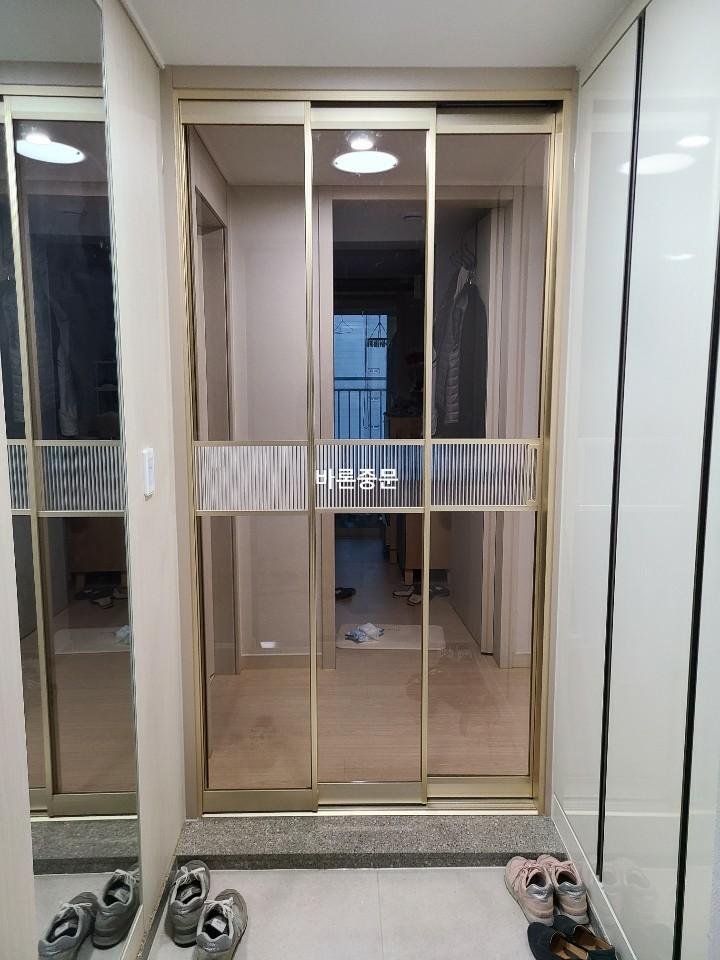 금색 프레임 중문이 설치된 현관 전경