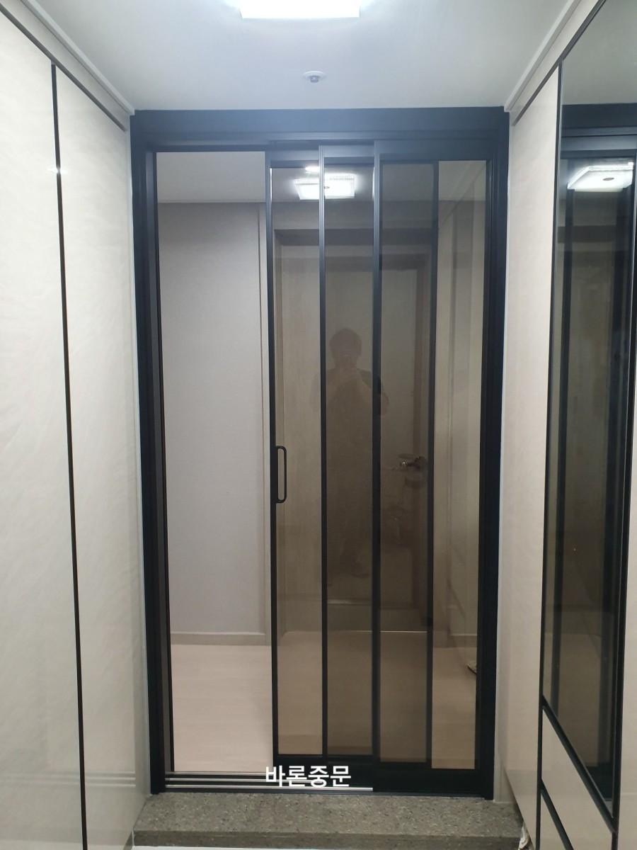 검은색 프레임의 슬라이딩 도어가 설치된 복도