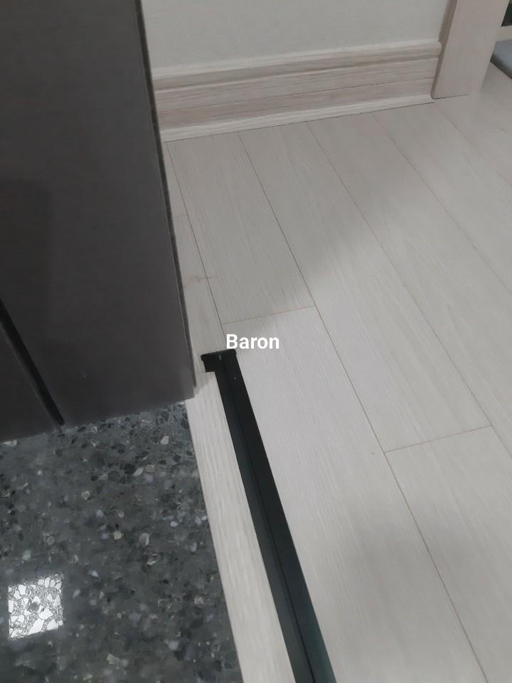 바닥 타일과 검은색 라인이 맞닿은 하단 마감