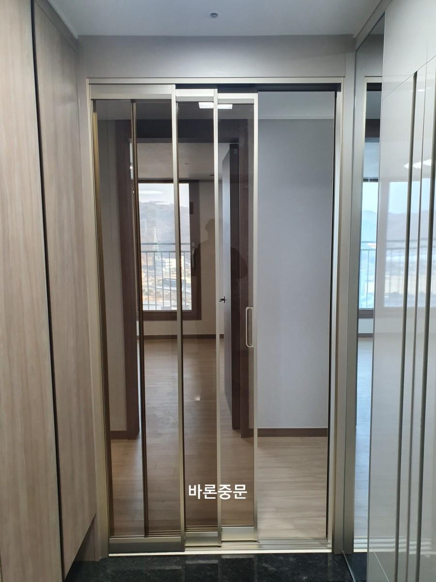 슬라이딩 도어의 금속 프레임과 유리 패널 모습