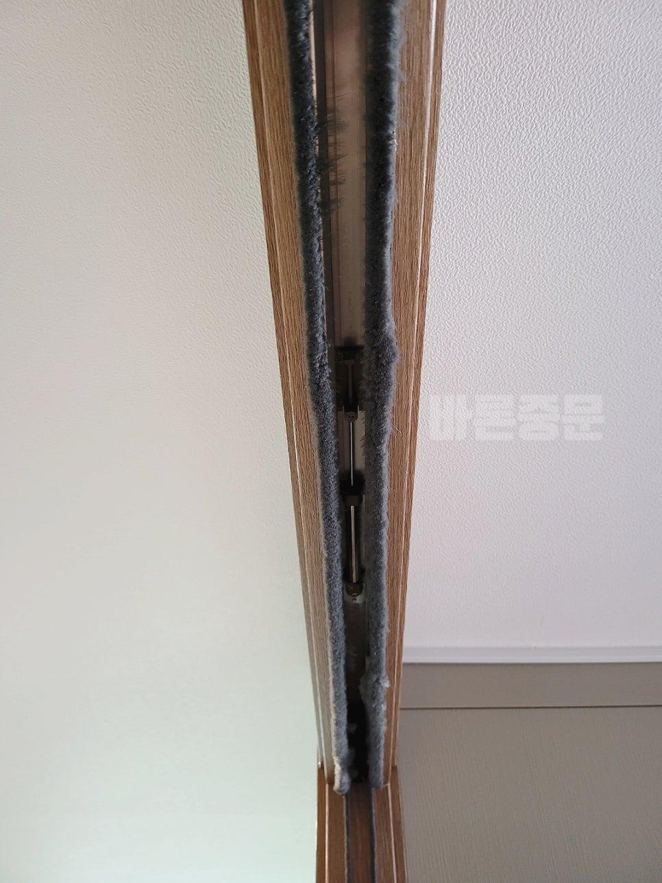 문의 틈새에 설치된 회색 마감재 근접 사진