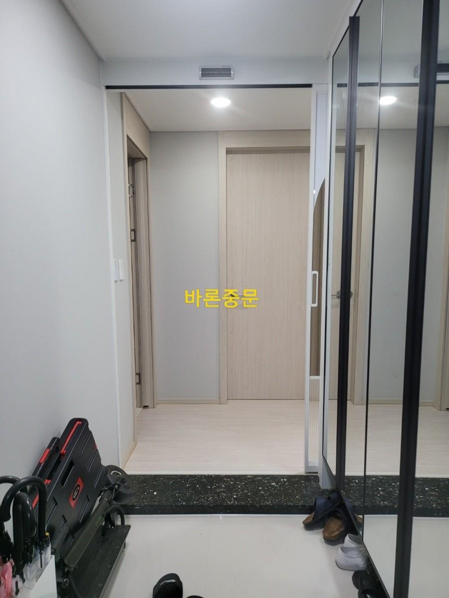 자동문 센서와 공기 순환기가 배치된 현관 벽면