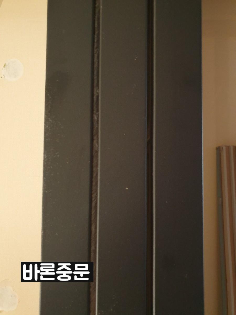 블랙 도어 프레임과 벽면의 밀착 마감 디테일