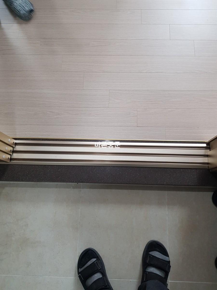 바닥 타일과 마루재 경계에 설치된 하부 레일 구조