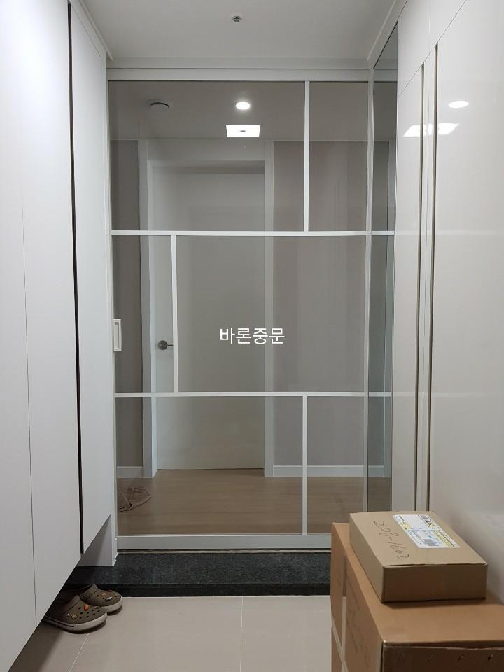 마루 보양재가 깔린 상태에서 중문을 설치 중인 과정