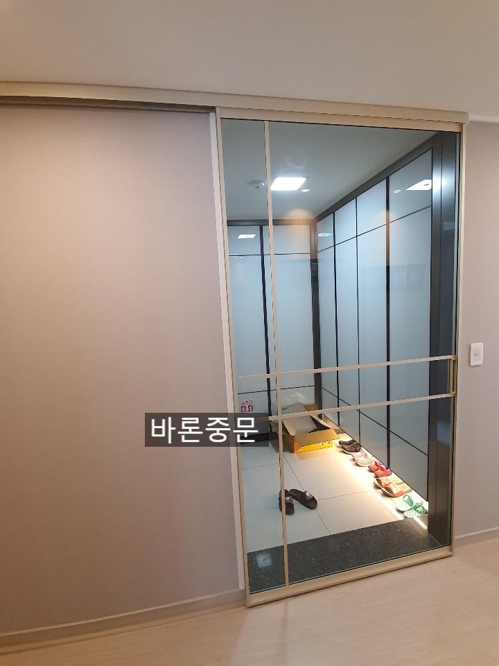 문이 열린 상태에서 보이는 현관 타일 바닥과 프레임