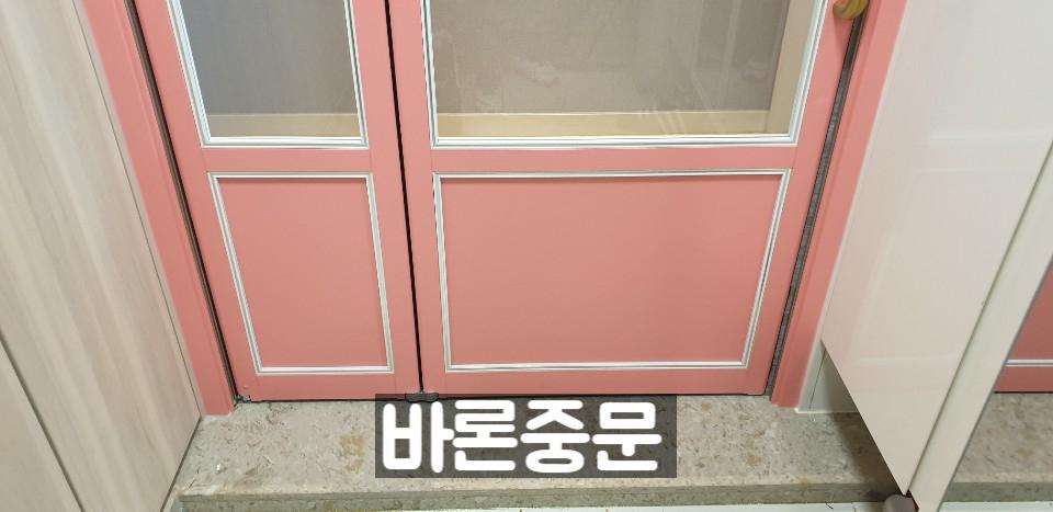 베이지색 바닥재와 핑크색 도어가 설치된 현관