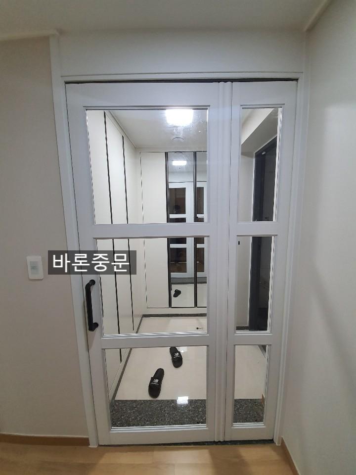 전기 스위치 옆으로 자리 잡은 흰색 여닫이문