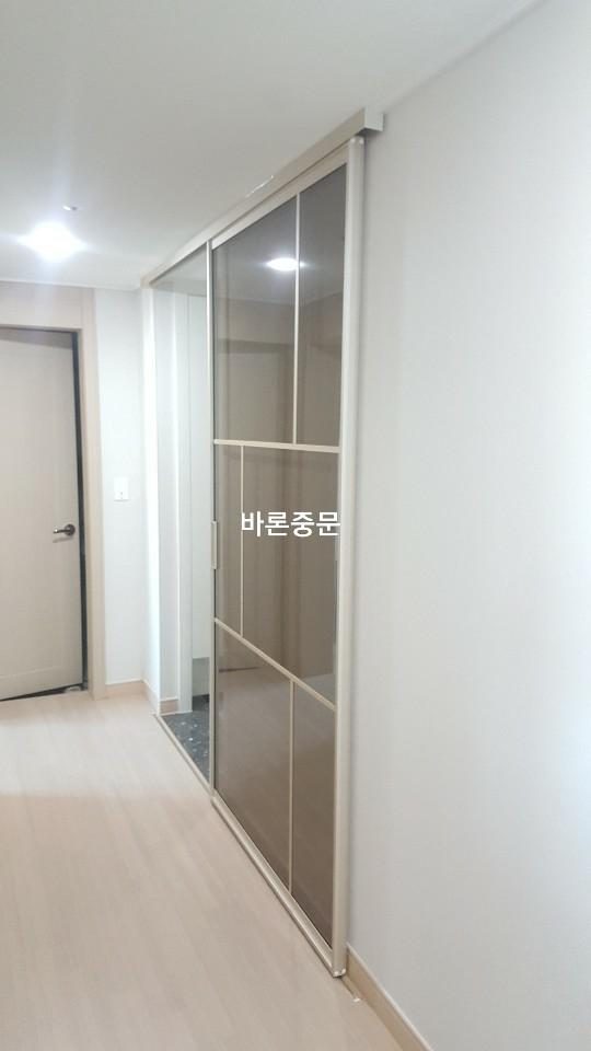 유리 패널 도어가 설치된 복도와 내부 수납장 모습