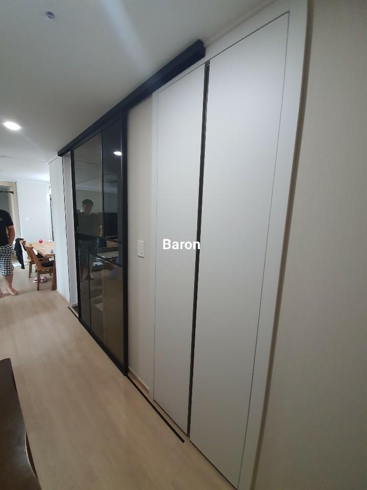 복도 수납장과 연결된 슬라이딩 도어와 배경의 식탁 공간