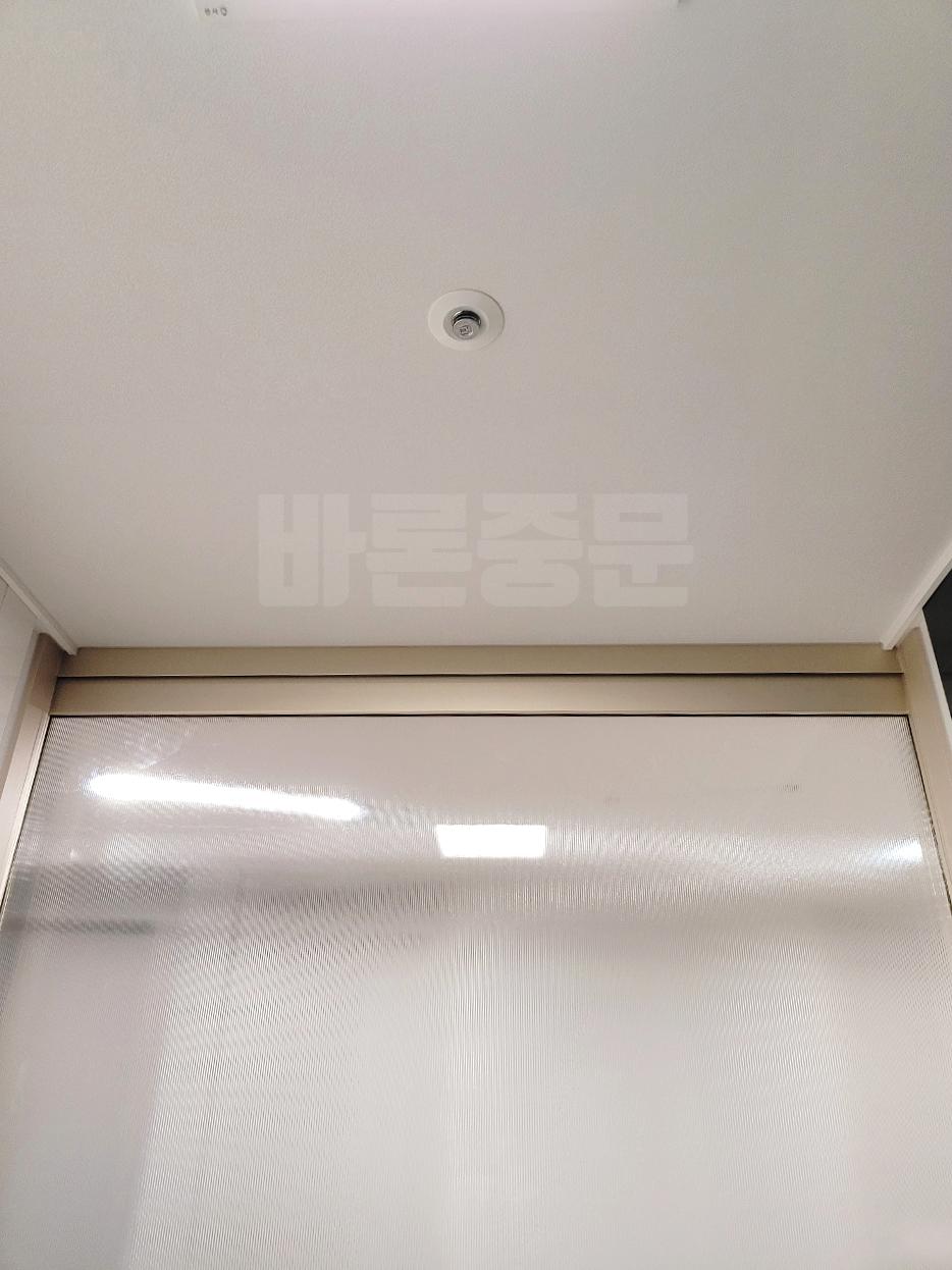 조명 아래 은은하게 빛나는 반투명 유리 도어